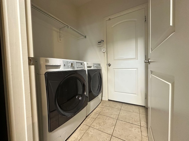 clothes washing area with light tile patterned floors and washing machine and dryer