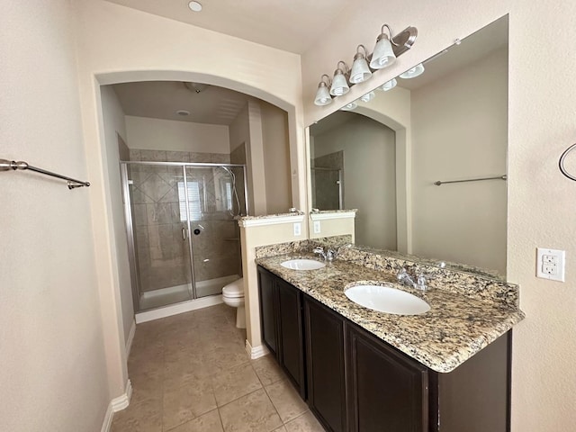 bathroom with tile patterned floors, walk in shower, vanity, and toilet