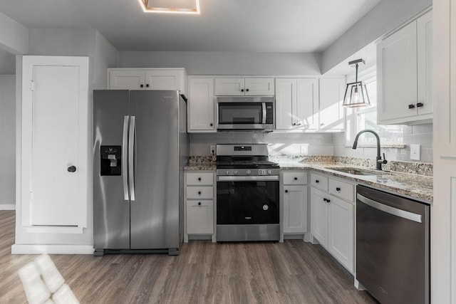 kitchen featuring white cabinets, hanging light fixtures, sink, and appliances with stainless steel finishes