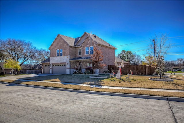 view of property featuring a garage and a front lawn