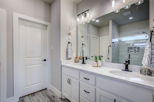 bathroom with a shower with door, vanity, and hardwood / wood-style floors