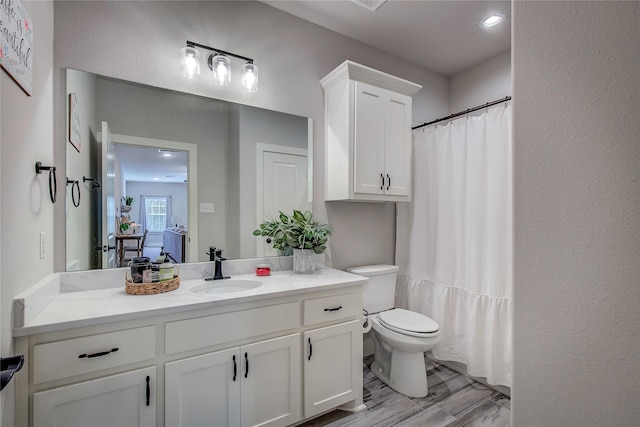 bathroom with a shower with curtain, vanity, toilet, and wood-type flooring