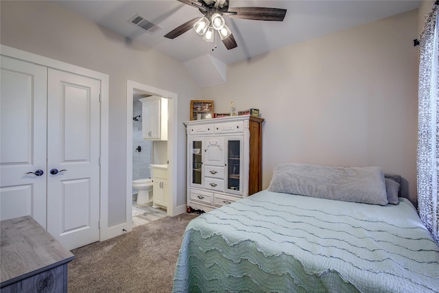 bedroom with ceiling fan, ensuite bathroom, and light carpet