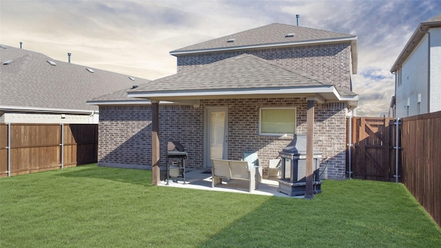 back of house with a yard and a patio