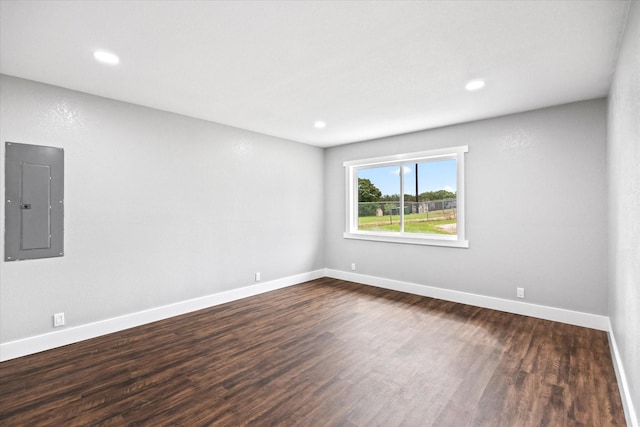 unfurnished room featuring dark hardwood / wood-style flooring and electric panel