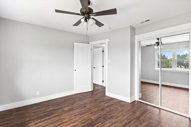 unfurnished bedroom with a closet, dark wood-type flooring, and ceiling fan