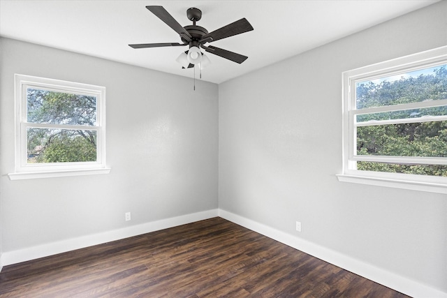 spare room with ceiling fan, dark wood-type flooring, and a wealth of natural light