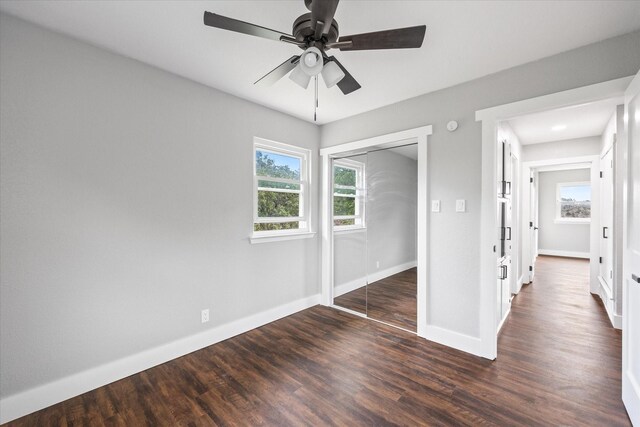 unfurnished bedroom with a closet, ceiling fan, and dark wood-type flooring