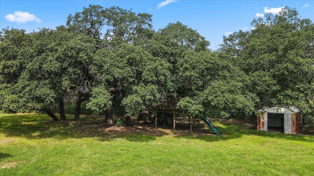 view of yard featuring a playground and a storage shed