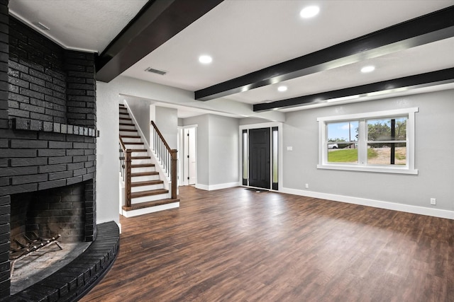 unfurnished living room with a fireplace, beam ceiling, and dark hardwood / wood-style flooring