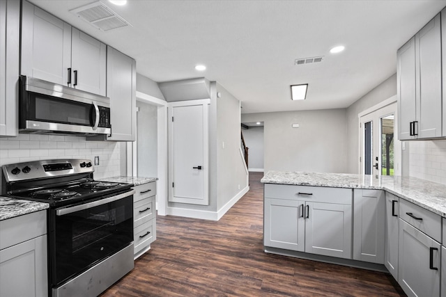 kitchen featuring decorative backsplash, dark hardwood / wood-style flooring, light stone counters, stainless steel appliances, and gray cabinets