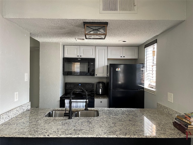 kitchen featuring black appliances, white cabinets, sink, light stone countertops, and a textured ceiling