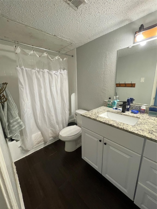 full bathroom with shower / bathtub combination with curtain, vanity, a textured ceiling, and toilet