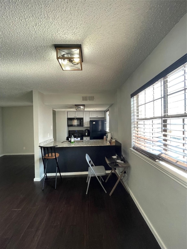 office with a textured ceiling and dark hardwood / wood-style flooring