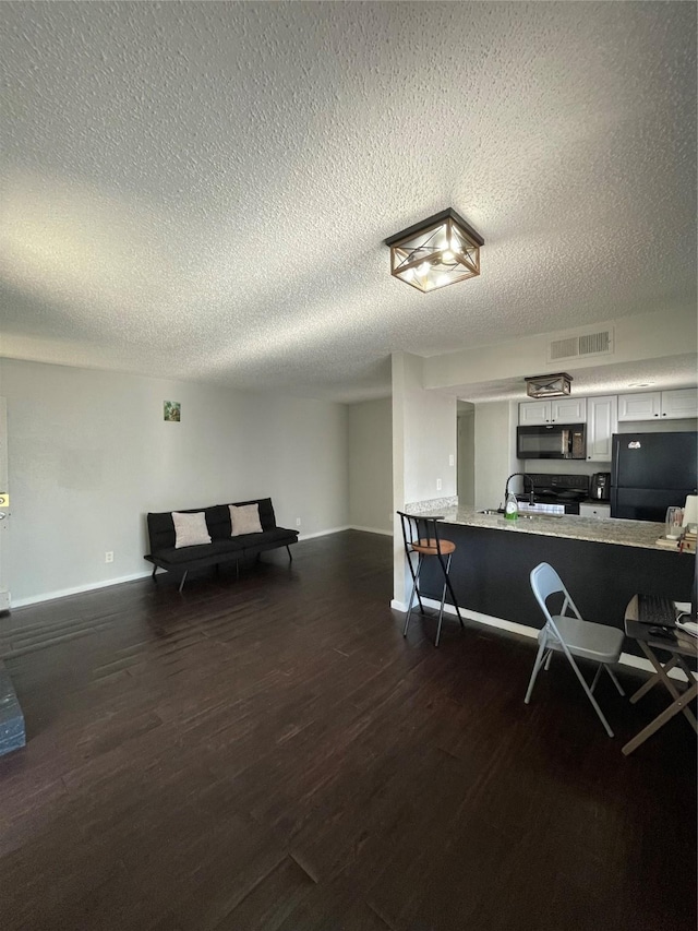 interior space featuring sink, dark hardwood / wood-style flooring, and a textured ceiling