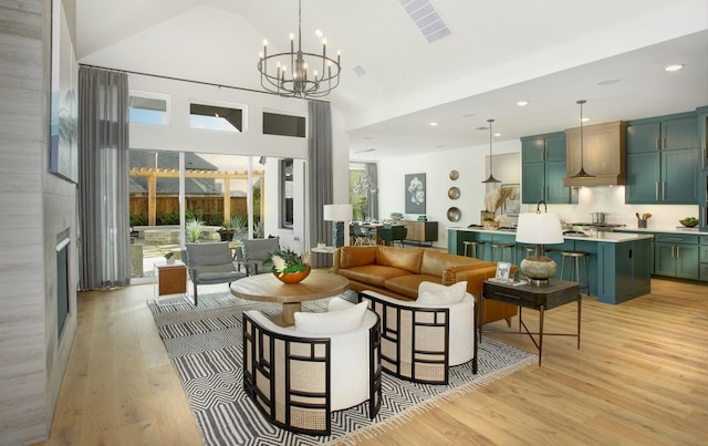 living room featuring a fireplace, light hardwood / wood-style flooring, a chandelier, and vaulted ceiling