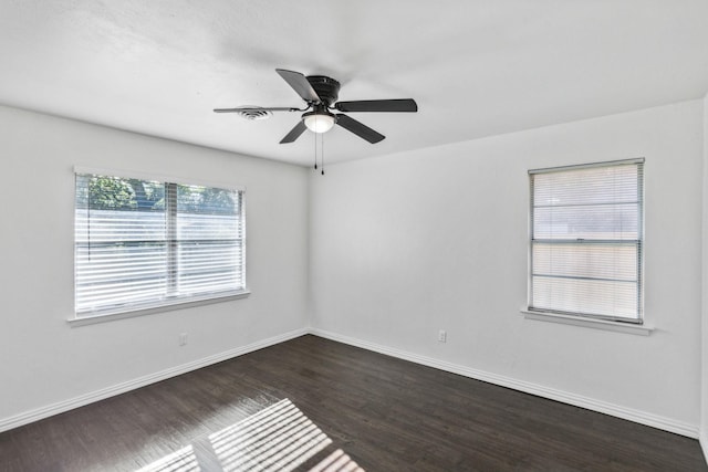 empty room with ceiling fan and dark hardwood / wood-style flooring