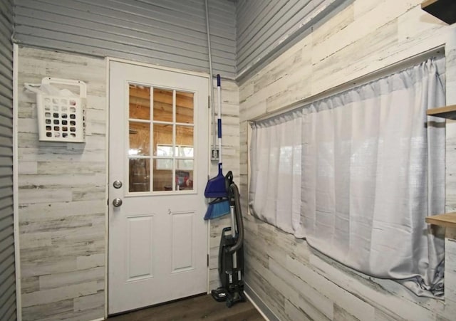 entryway with dark hardwood / wood-style flooring and wooden walls