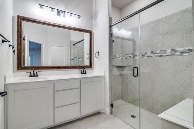 full bathroom featuring double vanity, a stall shower, and a sink