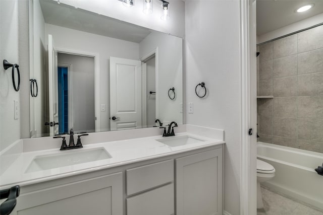 full bathroom featuring double vanity, shower / bath combination, a sink, and toilet