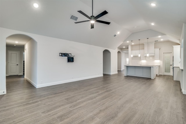 unfurnished living room with vaulted ceiling, light hardwood / wood-style flooring, and ceiling fan