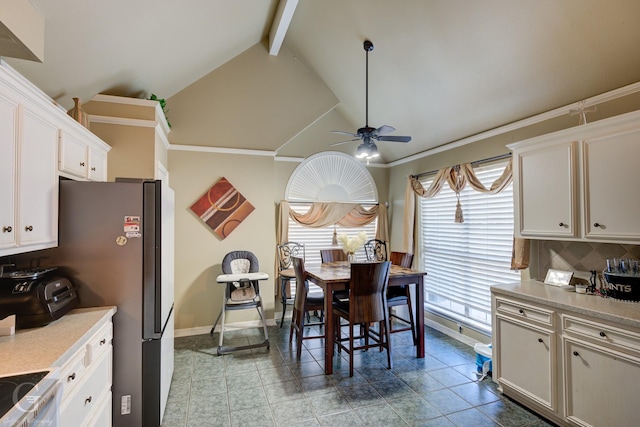 kitchen with white cabinetry, ceiling fan, tasteful backsplash, vaulted ceiling with beams, and stainless steel fridge