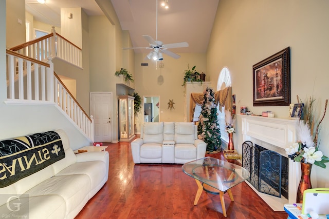 living room featuring hardwood / wood-style flooring, ceiling fan, and a high ceiling