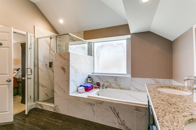 bathroom with a bathing tub, lofted ceiling, vanity, and hardwood / wood-style flooring