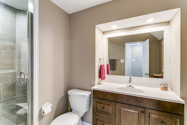 bathroom with toilet, an enclosed shower, and vanity