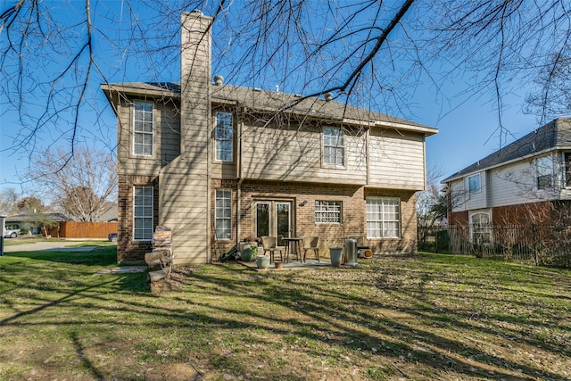 back of house featuring a lawn and a patio area