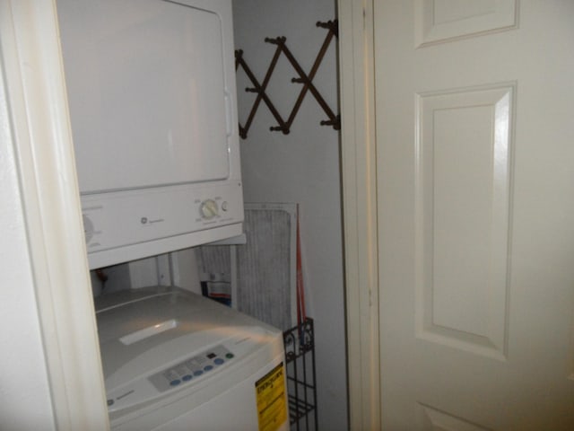 clothes washing area featuring stacked washing maching and dryer