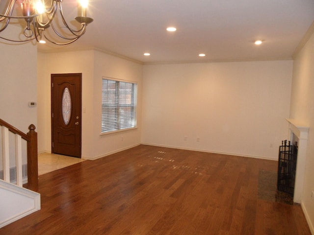 entrance foyer with a notable chandelier, hardwood / wood-style flooring, and ornamental molding