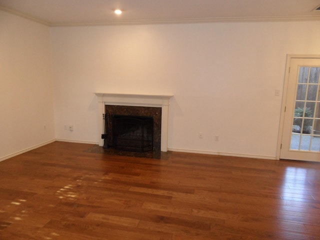 unfurnished living room with crown molding, a high end fireplace, and dark wood-type flooring