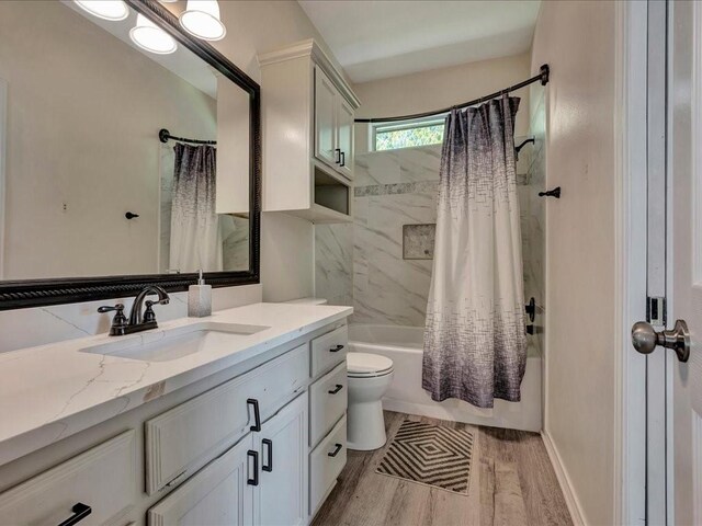 full bathroom with wood finished floors, vanity, toilet, and shower / bath combo with shower curtain