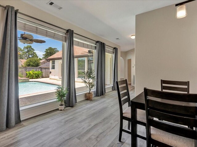 dining area with ceiling fan, visible vents, and wood finished floors