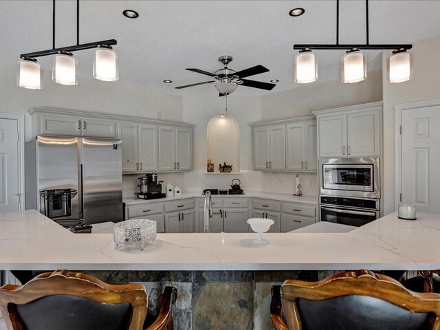 kitchen featuring stainless steel appliances, a breakfast bar area, and pendant lighting