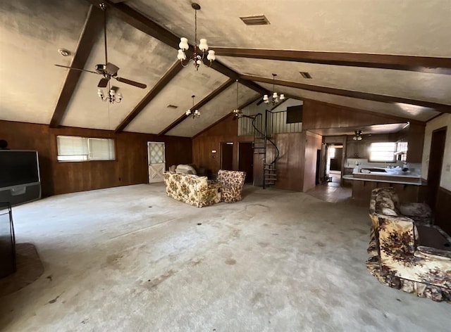 interior space with vaulted ceiling with beams, wood walls, and ceiling fan with notable chandelier