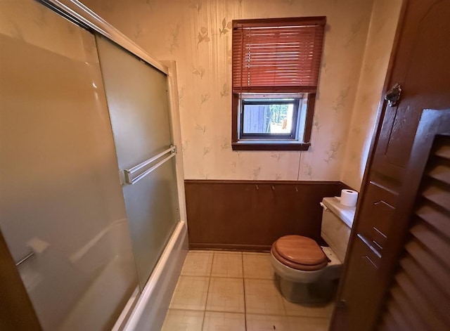 bathroom featuring wood walls and toilet