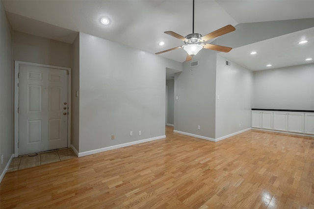 empty room featuring ceiling fan, light hardwood / wood-style flooring, and lofted ceiling