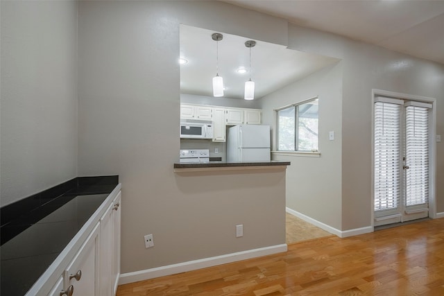 kitchen featuring white appliances, kitchen peninsula, light wood-type flooring, decorative light fixtures, and white cabinetry