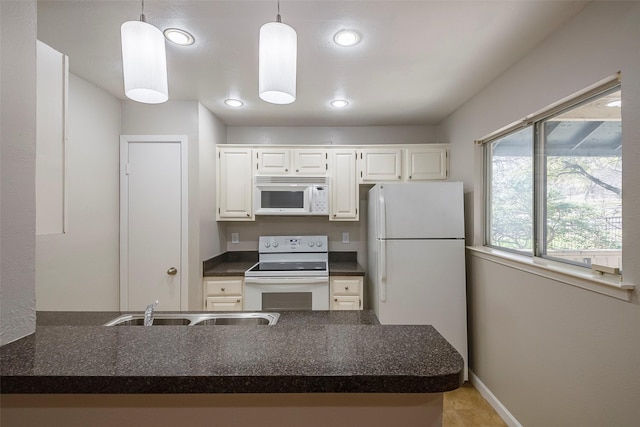 kitchen with white appliances, white cabinets, sink, hanging light fixtures, and kitchen peninsula