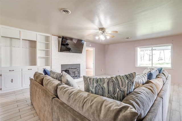 living room featuring ceiling fan and a wood stove