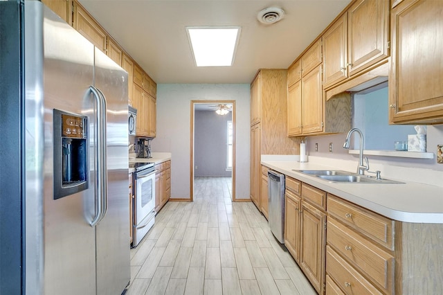 kitchen with ceiling fan, sink, light wood-type flooring, and appliances with stainless steel finishes