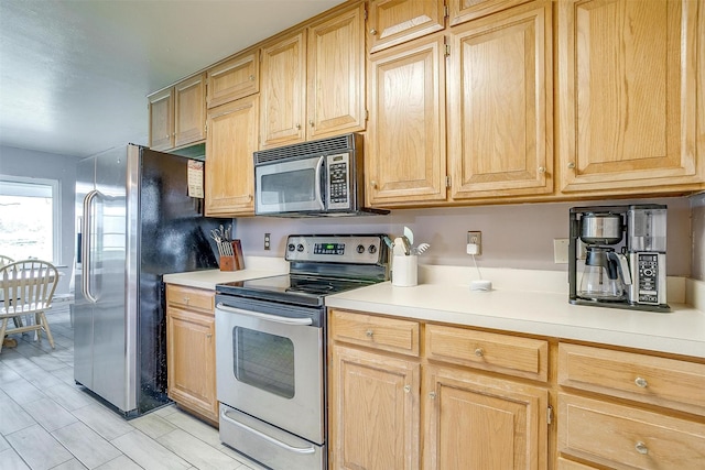 kitchen with light brown cabinetry and appliances with stainless steel finishes