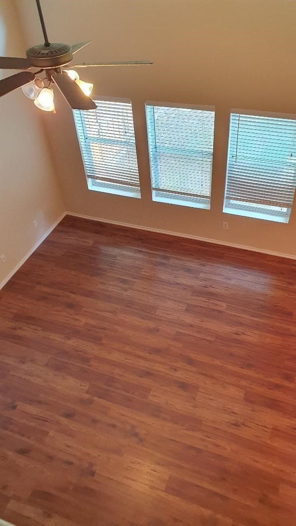 unfurnished room with ceiling fan and dark hardwood / wood-style flooring