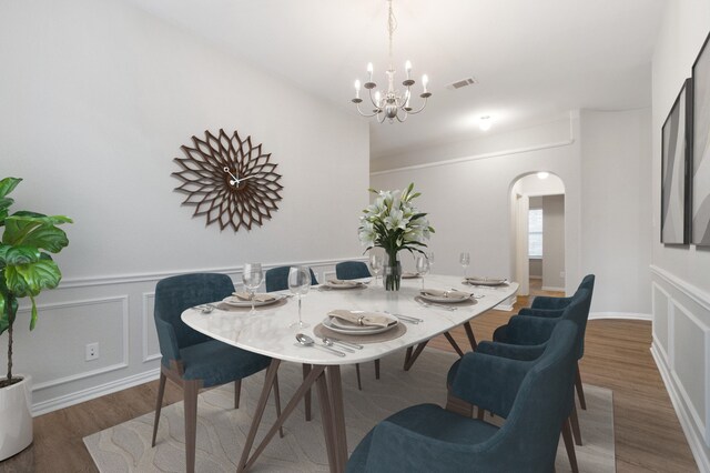 dining area with hardwood / wood-style flooring and an inviting chandelier