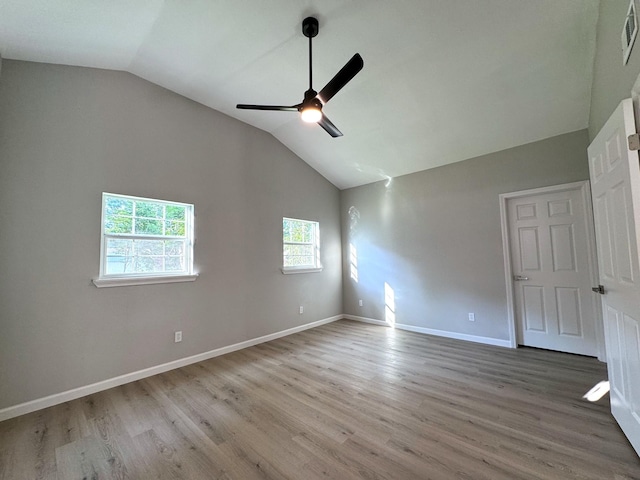 empty room featuring ceiling fan, vaulted ceiling, and hardwood / wood-style flooring