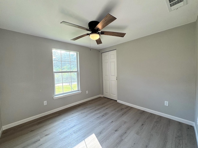 empty room with ceiling fan and light wood-type flooring