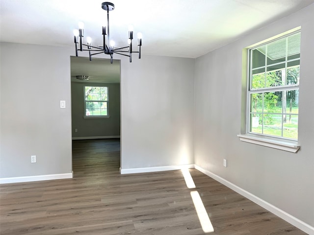 unfurnished dining area with dark hardwood / wood-style flooring and a notable chandelier