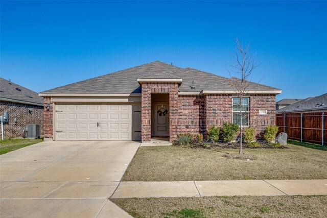 ranch-style house featuring central AC unit and a garage